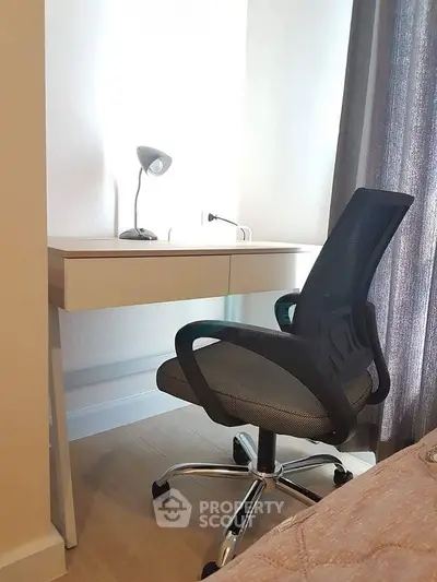 Cozy study nook with modern desk and ergonomic chair in a bright room.