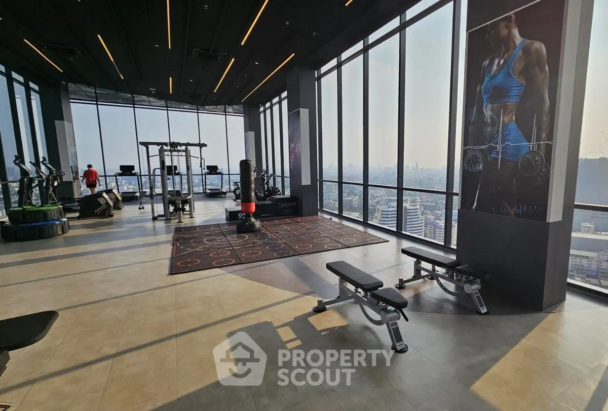 Spacious modern gym with panoramic city views and state-of-the-art fitness equipment.