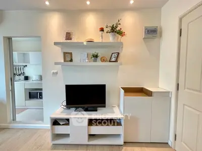 Modern living room with sleek white furniture and open kitchen layout