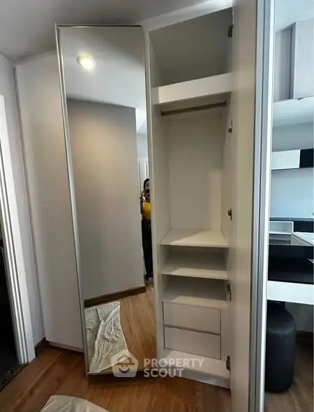 Modern wardrobe with mirror door and ample storage space in stylish apartment.