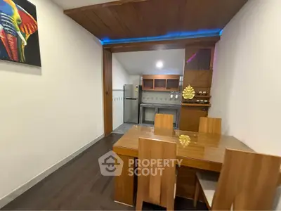 Modern dining area with wooden furniture and compact kitchen in open layout