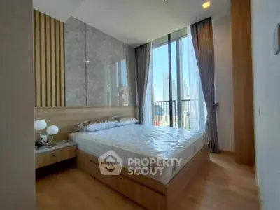 Modern bedroom with floor-to-ceiling windows and city view, featuring stylish decor and natural light.