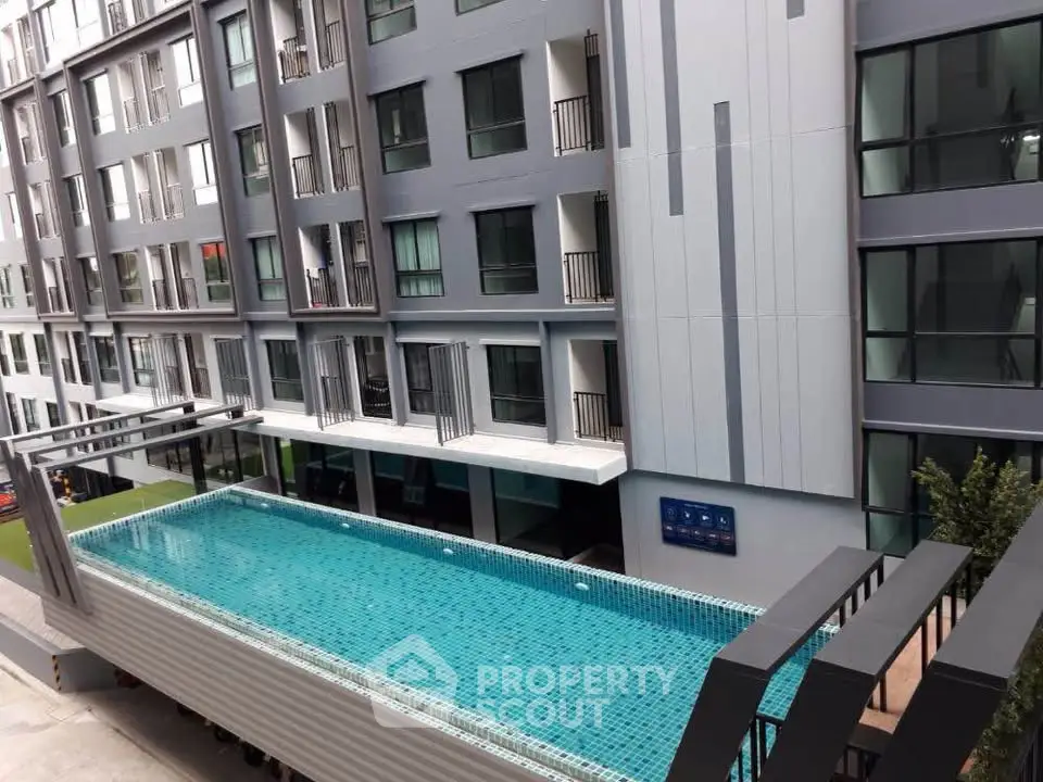 Modern apartment building with rooftop pool offering urban luxury living.