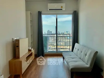 Modern living room with city view, featuring sleek furniture and large window for natural light.