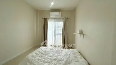Minimalist bedroom with cozy bedding and natural light from window