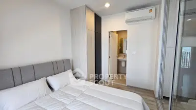 Modern bedroom with ensuite bathroom and air conditioning in stylish apartment.
