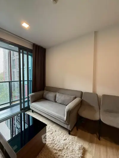 Modern living room with cozy sofa and large window in urban apartment