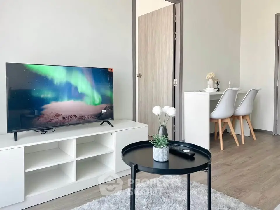 Modern living room with stylish decor and cozy dining area, featuring a sleek TV setup and elegant furniture.