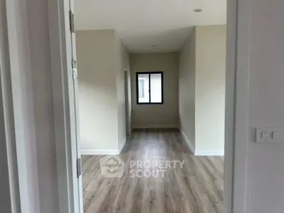 Spacious empty room with wooden flooring and natural light