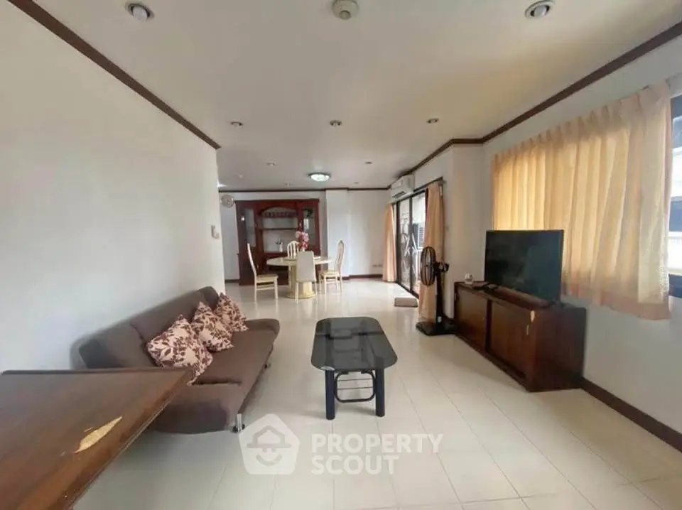 Spacious living room with modern decor and ample natural light, perfect for relaxation and entertainment.