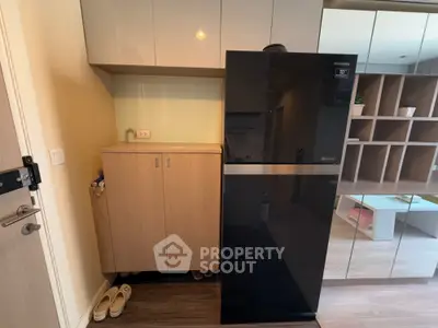 Modern kitchen with sleek black refrigerator and wooden cabinetry