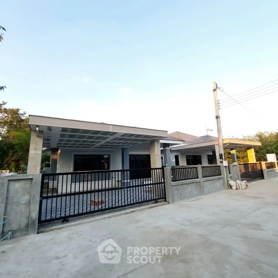 Modern single-story house with spacious driveway and sleek metal gate