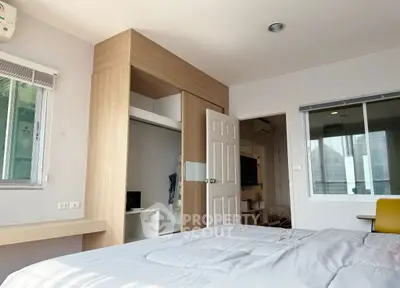 Modern bedroom with built-in closet and large window view