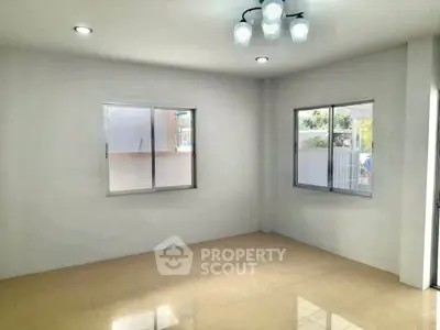Spacious empty room with large windows and modern lighting