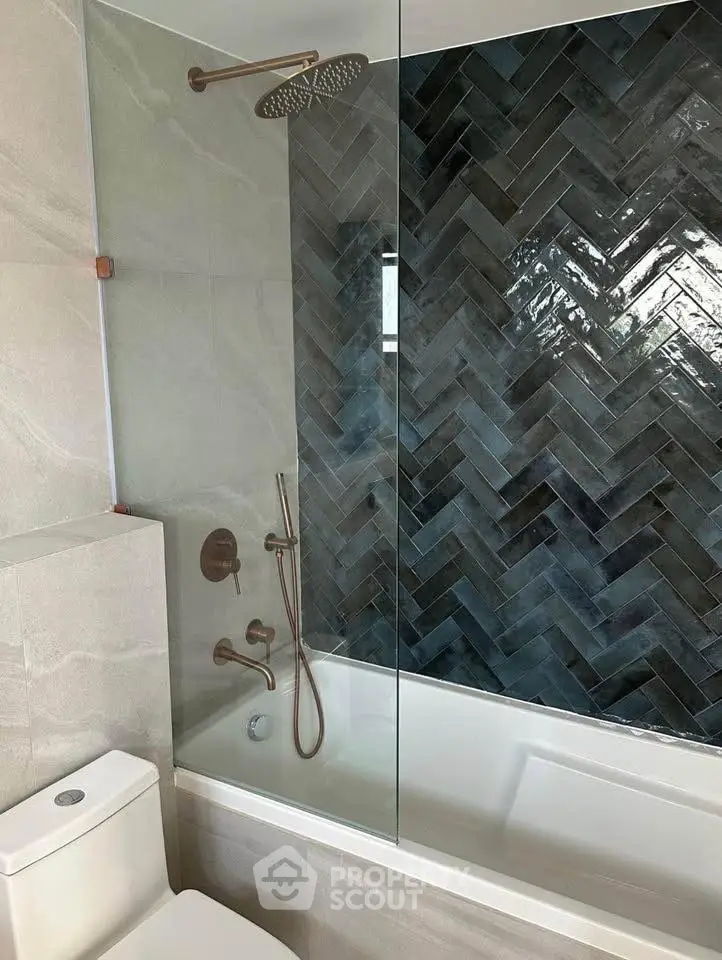 Modern bathroom with elegant herringbone tile and rainfall showerhead