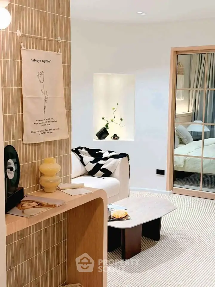 Stylish modern living room with cozy decor and open view into bedroom