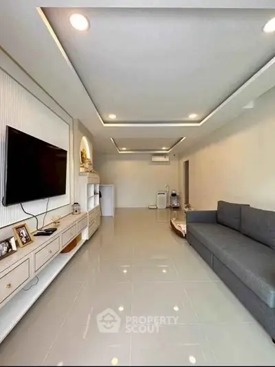 Spacious modern living room with sleek design and wall-mounted TV