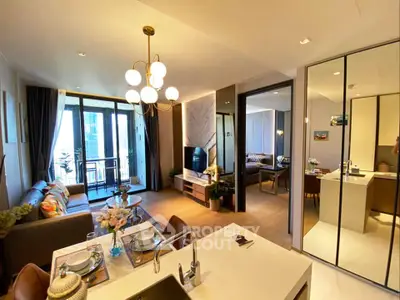Luxurious open-plan living room with modern kitchen and balcony view in upscale apartment.