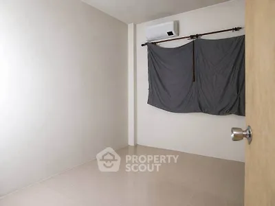 Minimalist empty room with air conditioning and curtain-covered window, ideal for customization.