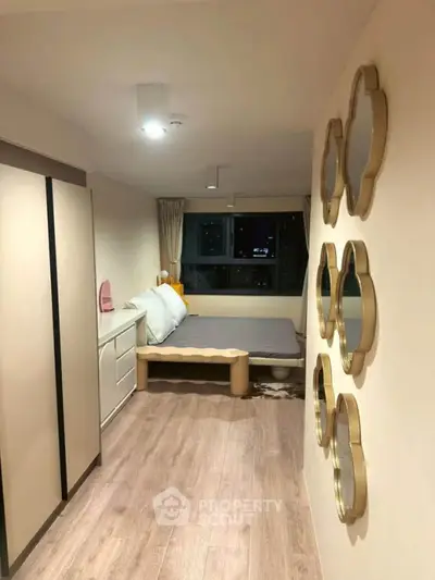 Cozy bedroom with modern decor and unique wall mirrors, featuring a compact bed and stylish wardrobe.