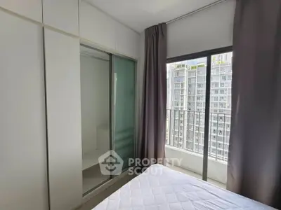 Modern bedroom with large window and built-in closet offering city views