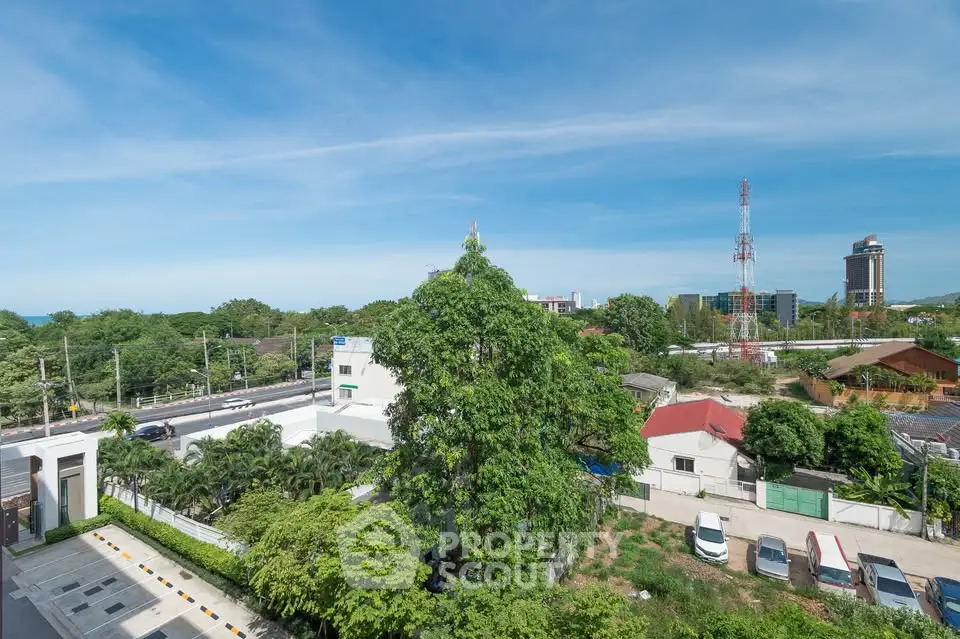 Stunning aerial view of lush greenery and urban landscape under a clear blue sky.