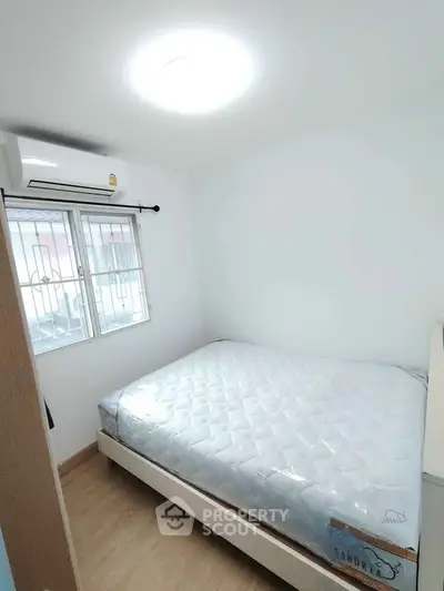 Cozy bedroom with natural light and modern air conditioning unit.