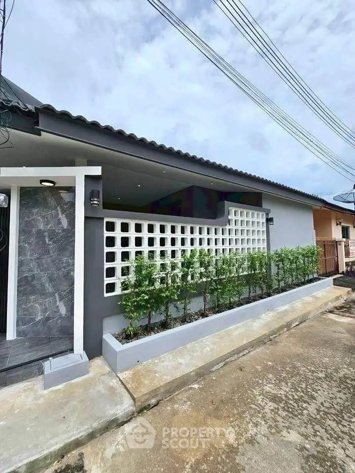 Modern single-story house with stylish facade and lush greenery