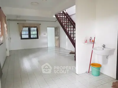 Spacious open-plan living area with staircase and tiled flooring