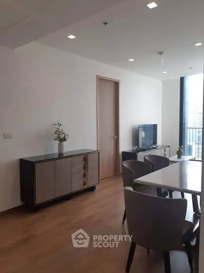 Modern living room with sleek furniture and large windows offering natural light.
