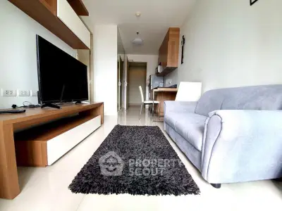 Modern living room with sleek furniture and open kitchen layout in a stylish apartment.