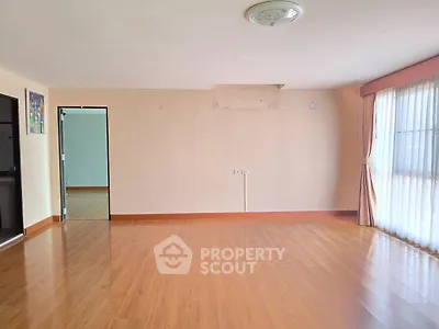 Spacious empty living room with wooden flooring and large window