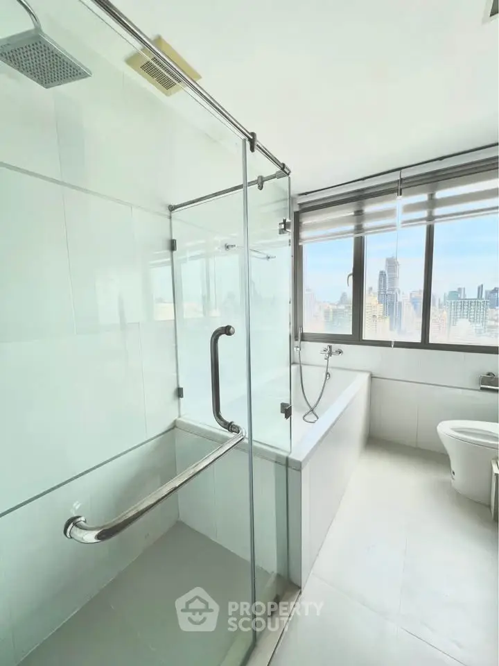Spacious modern bathroom with city view and glass shower enclosure