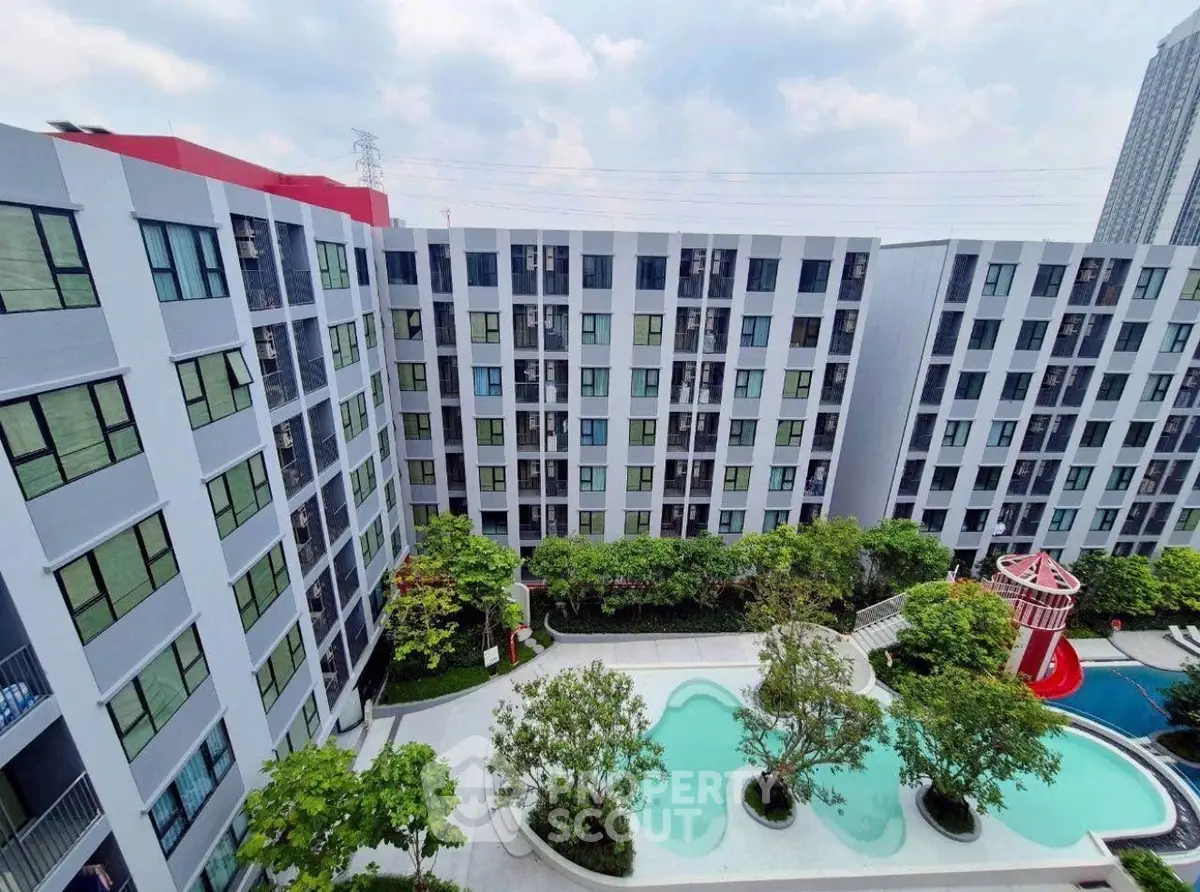 Modern apartment complex with pool and lush greenery, perfect for urban living.