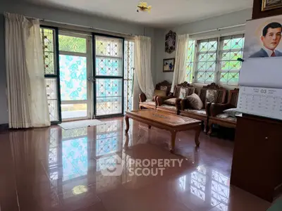 Spacious living room with elegant wooden furniture and large windows for natural light.