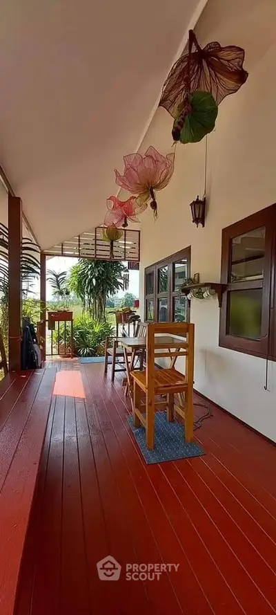Charming wooden balcony with outdoor dining set and lush garden view.