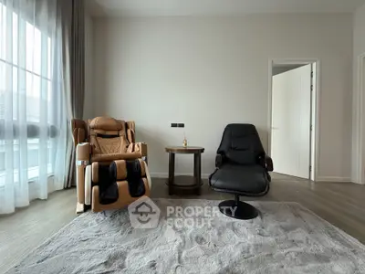 Modern living room with massage chair and sleek armchair, perfect for relaxation.