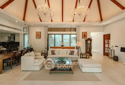 Luxurious living room with high ceilings, elegant chandeliers, and stylish decor in a spacious open layout.