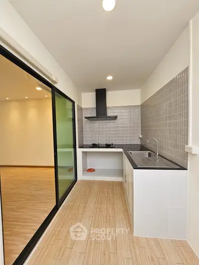 Modern kitchen with open layout and gas stove, featuring sleek design and ample natural light.