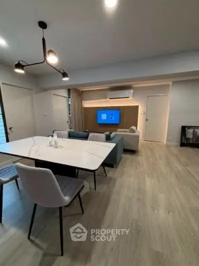 Modern living room with stylish dining area and contemporary lighting.