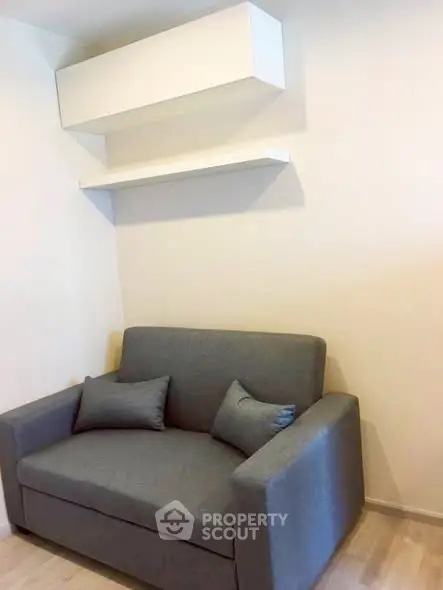 Cozy living room with modern gray sofa and minimalist shelving