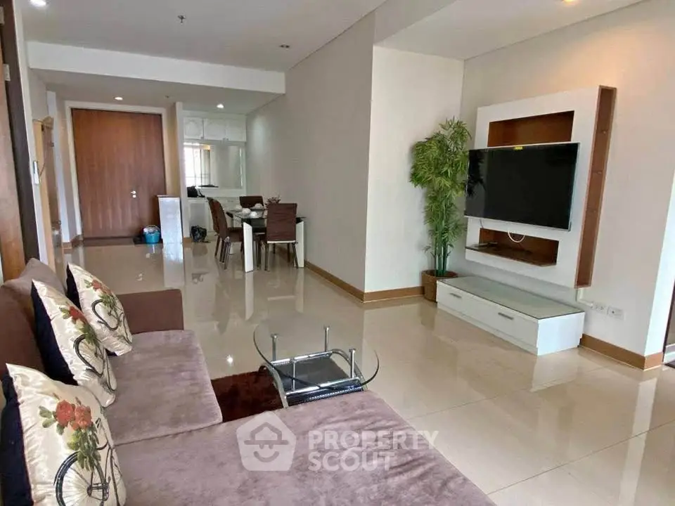 Spacious living room with modern decor and wall-mounted TV in a stylish apartment.