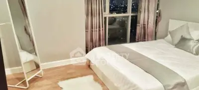 Elegant bedroom with city view, featuring a cozy bed and stylish decor.