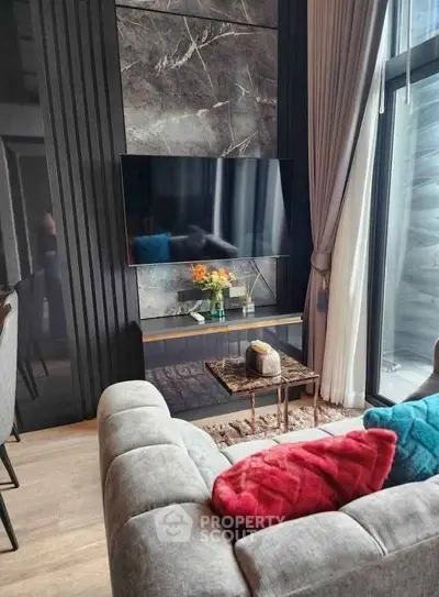 Modern living room with stylish decor, large TV, and cozy seating area.