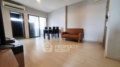Spacious modern living room with wooden flooring and stylish furniture in a contemporary apartment.