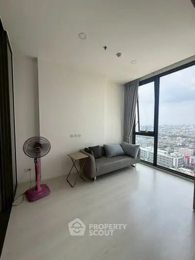 Modern living room with city view, featuring a cozy sofa and stylish decor.
