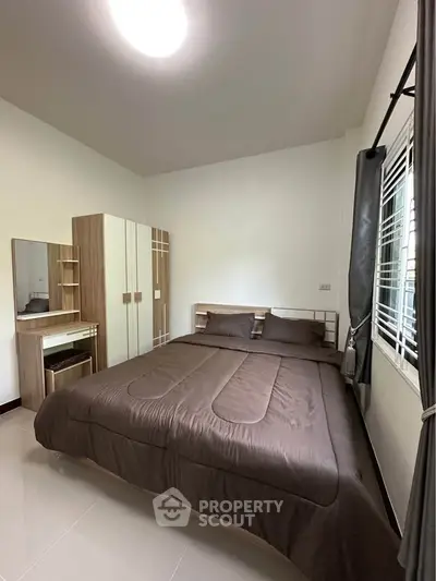 Cozy bedroom with modern furniture and large window for natural light