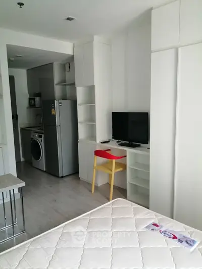 Modern studio apartment with compact kitchen and cozy workspace