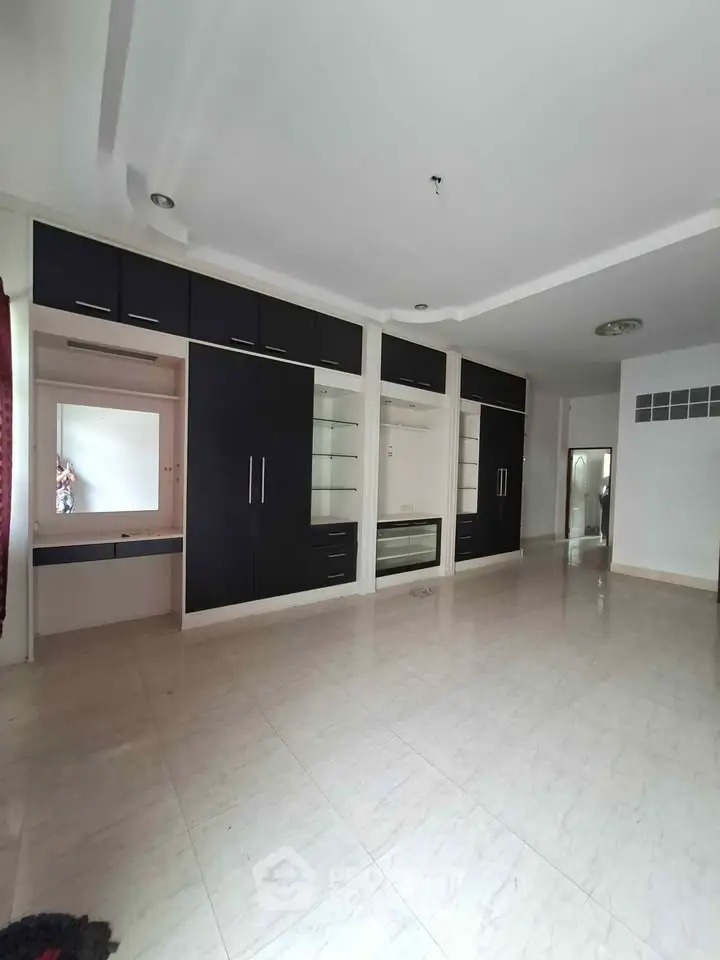 Spacious living room with built-in cabinets and sleek tile flooring