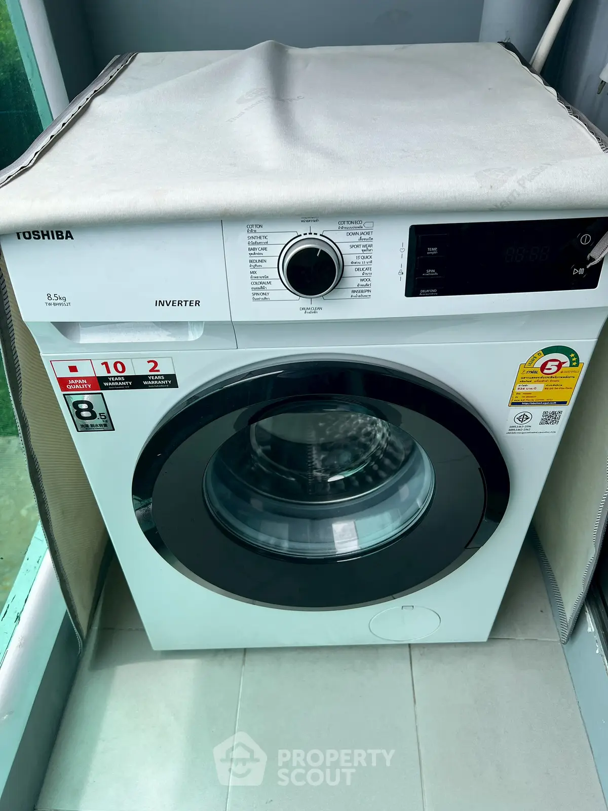 Modern washing machine in a sleek laundry area with tiled flooring.